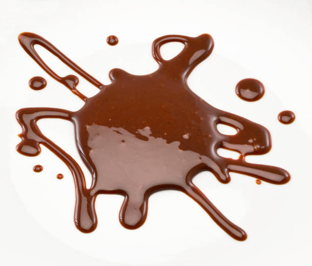 Chocolate syrup Chocolate syrup poured on a white surface. Studio photography. Cut out. High angle view. Indoors. Copy space. molten stock pictures, royalty-free photos & images