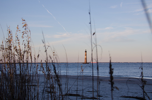 Beach grasses and reeds form a natural frame with the Morris Island Lighthouse in Folly Beach South Carolina at Sunset