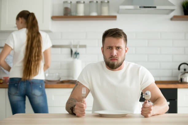 istock Dissatisfied man waiting for dinner cooked by wife 1060280810