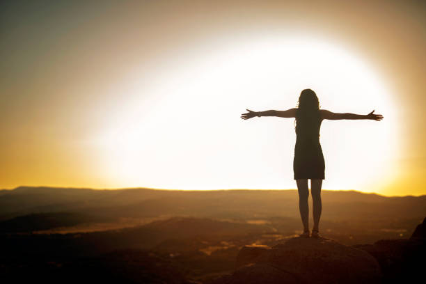 istock Woman Silhouette at sunset on hill 1060283856
