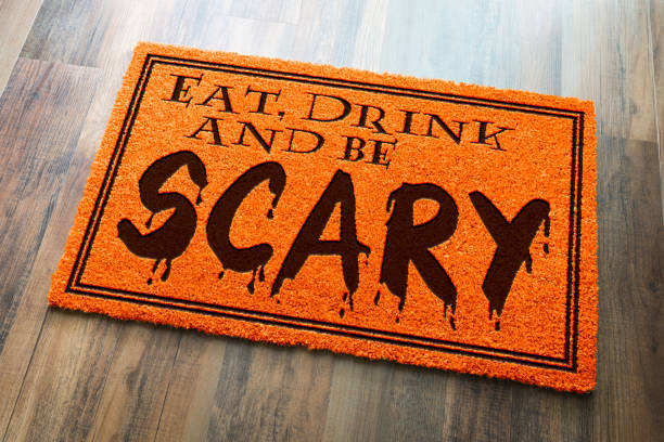 mangia, bevi ed essere spaventoso tappetino di benvenuto arancione di halloween su sfondo pavimento in legno - welcome sign doormat greeting floor mat foto e immagini stock