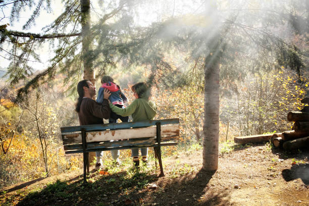 istock young mother and father with daughter sitting on park bench 1060311172