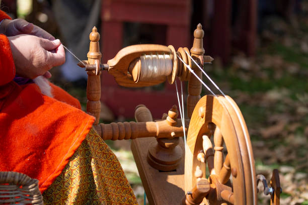 Female artisan spins yarn on an old-fashioned spinning wheel