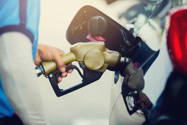 Photo of Hand refilling the car with fuel at the gas station