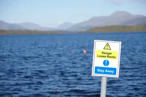 Loose rocks danger sign at coastal lake stay away message uk