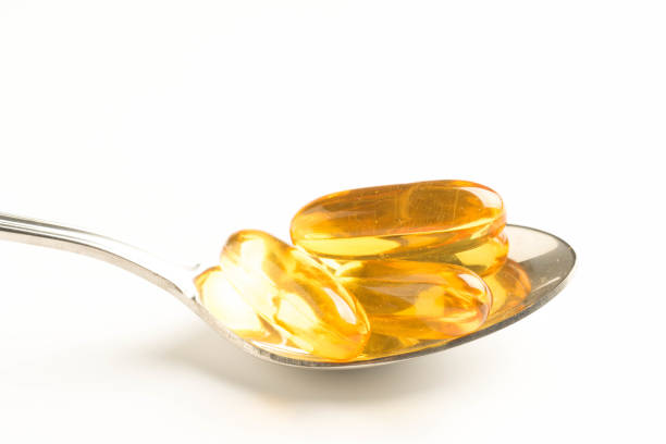 istock fish oil capsules in a spoon on white background 1060350284