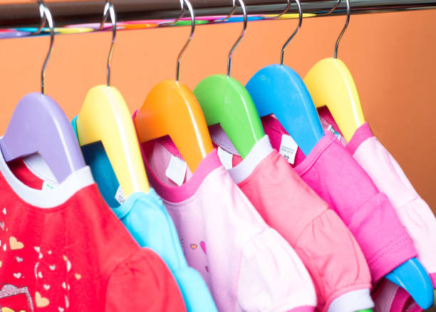istock Hangers with colourful clothes on orange background 1060357582
