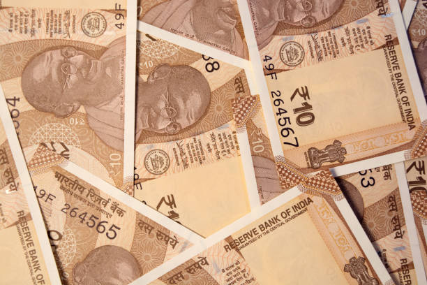 istock scattered Indian New 10 rupee currency notes on table. 1060358750