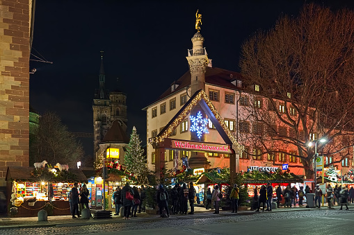 Stuttgart, Germany - December 14, 2017: The entrance to the Christmas market at the Schillerplatz (Schiller square) close to Stiftskirche (Collegiate Church) and Altes Schloss (Old Castle) in dusk. The Mercury Column is located behind the entrance arch. The Stuttgart Christmas market was officially mentioned for the first time in 1692
