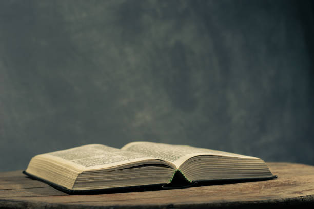 istock Bible on a round old wood table. Beautiful dark background. Religious concept. 1060381308
