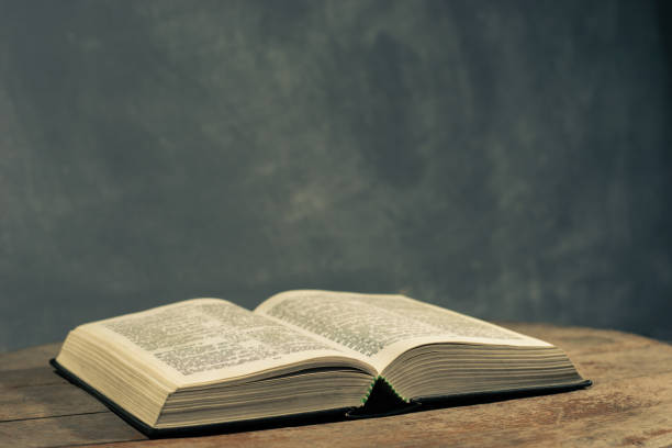istock Bible on a round old wood table. Beautiful dark background. Religious concept. 1060381338