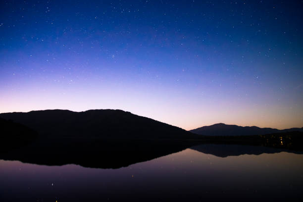 istock Stunning reflection starts and the mountain on the lake after sunset. 1060381400
