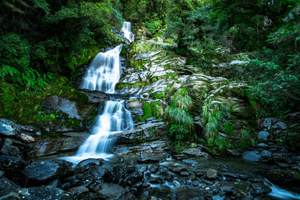 istock Beautiful waterfall falling from the high mountain. Midday scenery with blue sky. 1060381404