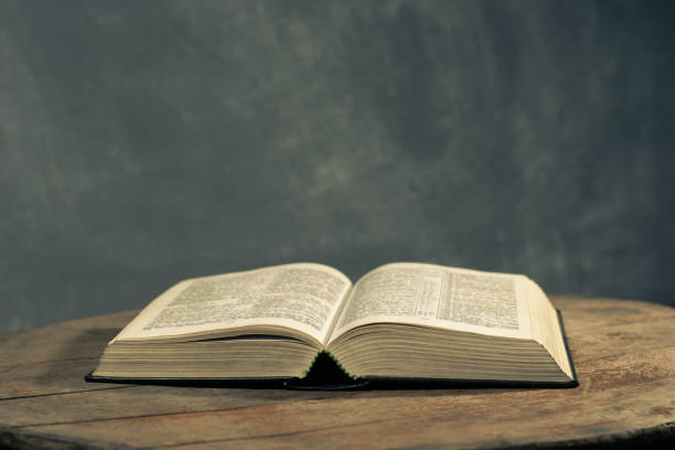 istock Bible on a round old wood table. Beautiful dark background. Religious concept. 1060381428