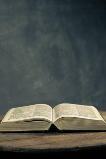istock Bible on a round old wood table. Beautiful dark background. Religious concept. 1060381434