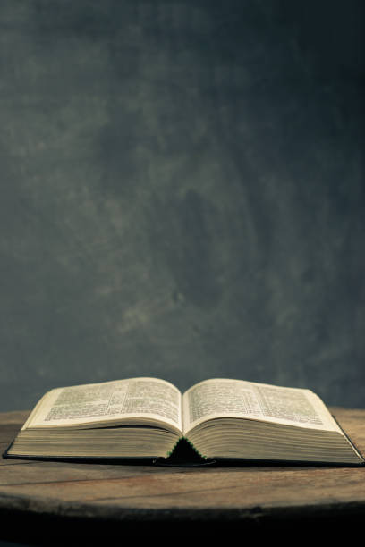 istock Bible on a round old wood table. Beautiful dark background. Religious concept. 1060381438