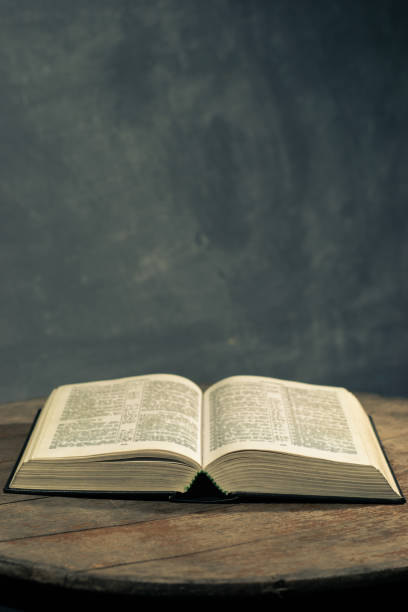 istock Bible on a round old wood table. Beautiful dark background. Religious concept. 1060382452