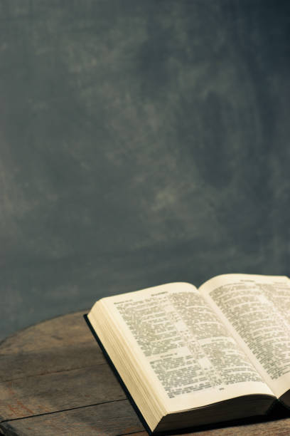istock Bible on a round old wood table. Beautiful dark background. Religious concept. 1060383572