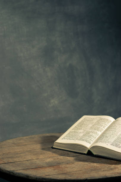 istock Bible on a round old wood table. Beautiful dark background. Religious concept. 1060383584