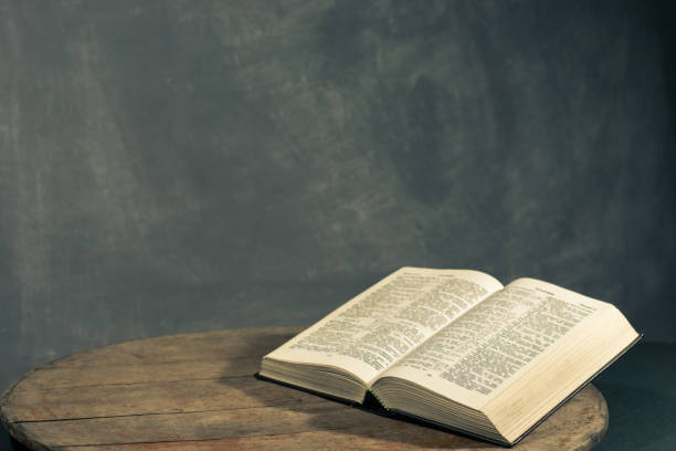 istock Bible on a round old wood table. Beautiful dark background. Religious concept. 1060383598