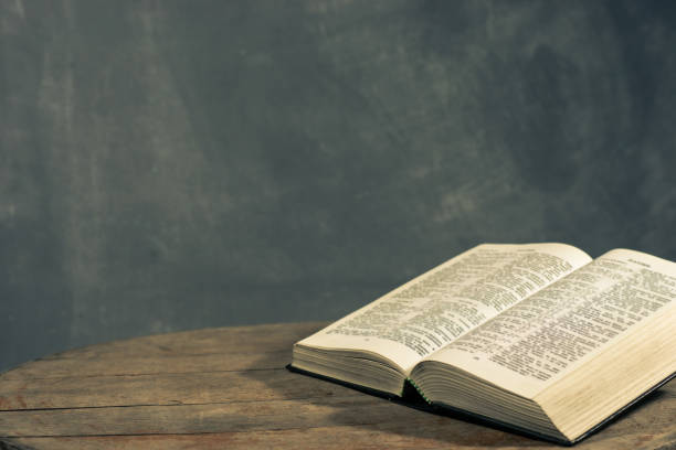 istock Bible on a round old wood table. Beautiful dark background. Religious concept. 1060383704