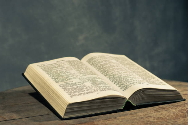 istock Bible on a round old wood table. Beautiful dark background. Religious concept. 1060383876