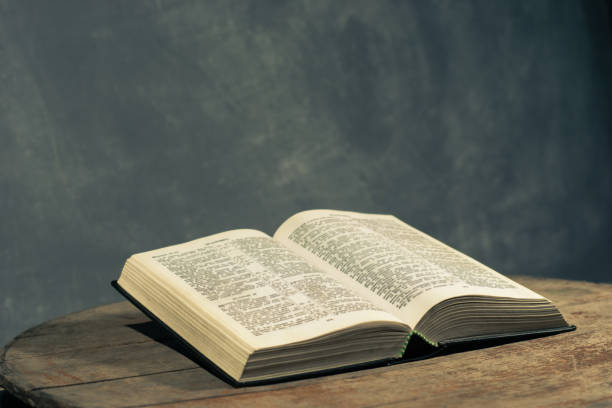 istock Bible on a round old wood table. Beautiful dark background. Religious concept. 1060383990