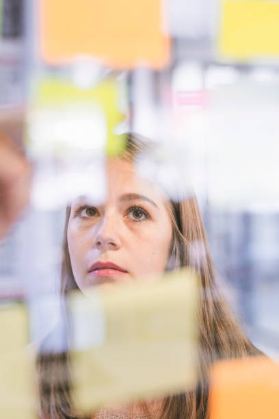istock Businesswoman looking at sticky notes on glass 1060387174