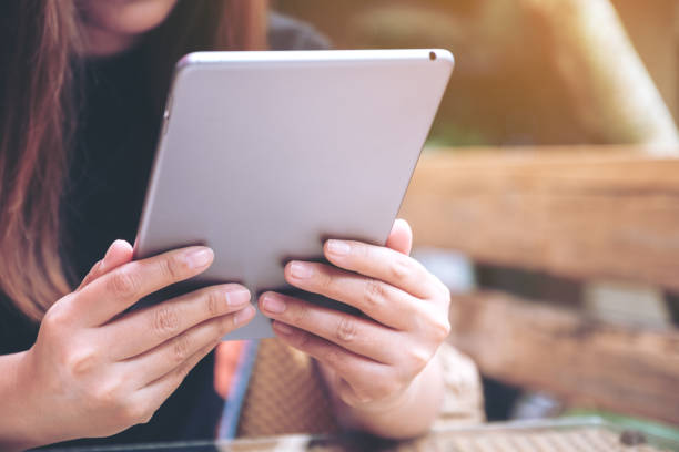 istock Closeup image of a woman holding and using tablet pc in cafe 1060388488