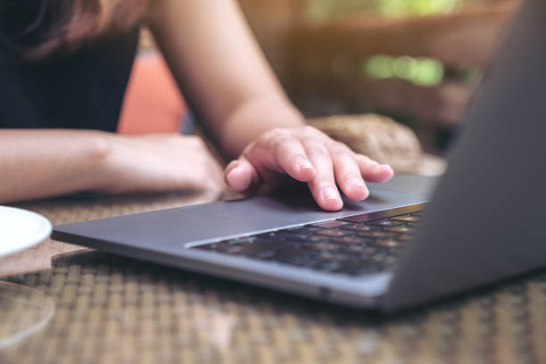 istock Closeup image of hands using and touching on laptop touchpad on wooden table 1060388748