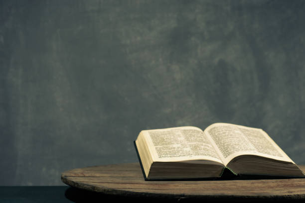 istock Bible on a round old wood table. Beautiful dark background. Religious concept. 1060389166