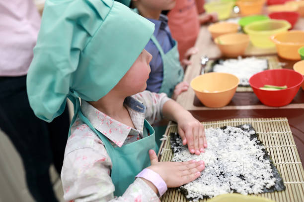 istock Child spreading rice over nori 1060390682