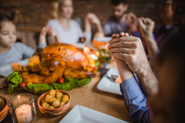 close-up de mãos humanas durante um rezar no jantar de ação de graças. - family thanksgiving dinner praying - fotografias e filmes do acervo
