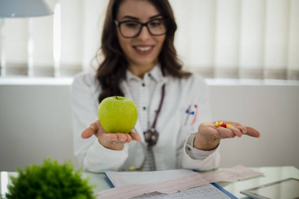 istock Female doctor working at office desk and smiling at camera, office interior 1060392958