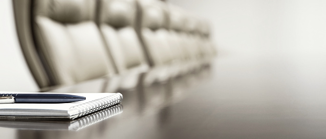 Close-up of notepad kept on table in empty conference room