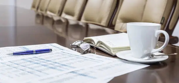 Close-up of notepad kept on table in empty conference room