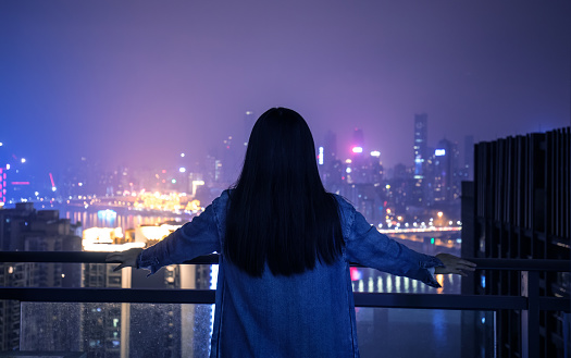 Young woman looking city night