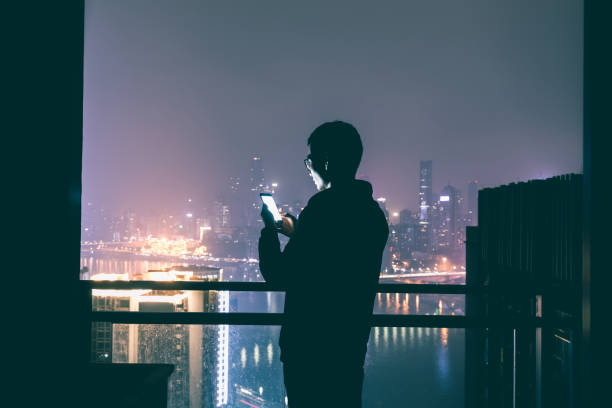 istock Young man alone with mobile phone at night 1060397080