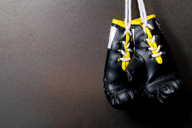 istock two hanging black boxing gloves on black background 1060398604