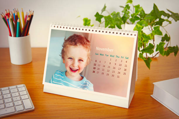 Calendar with photo of a child on the table Personalized calendar with photo of a boy on wooden table graphic print photos stock pictures, royalty-free photos & images