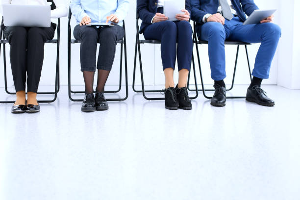 istock Group of business people sitting in office and waiting for job interview while using gadgets, close-up. Conference or training concepts. 1060399102