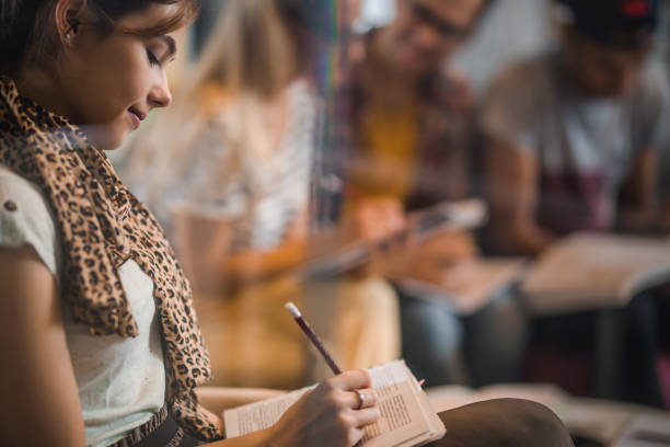 istock Profile view of female student taking notes in a book. 1060400488