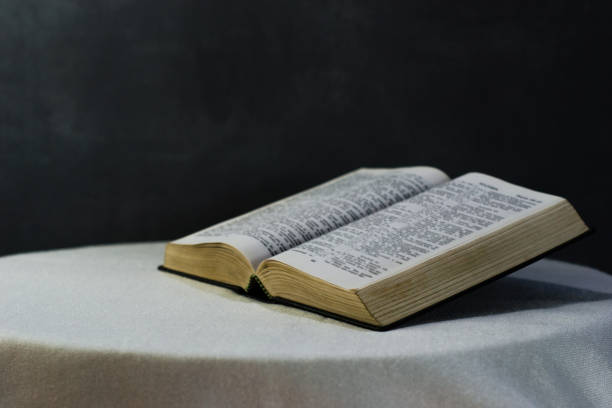 istock Bible on a round white table with beads. Beautiful dark background. Religious concept. 1060405458