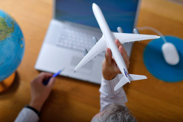 istock Planning a Flight with Laptop and Aircraft model 1060410396