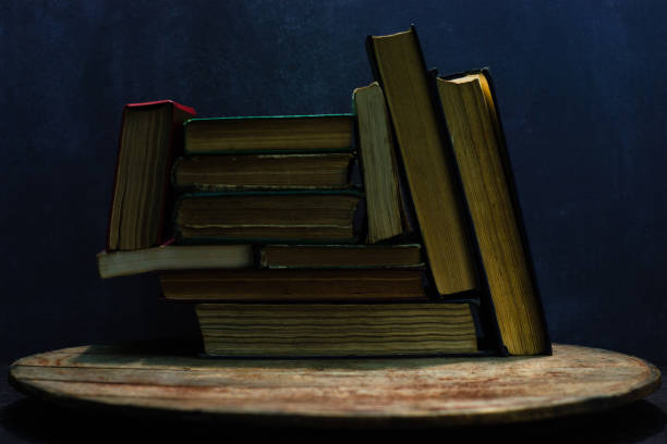 istock One open old book on a round wooden table. Beautiful dark background. 1060410506
