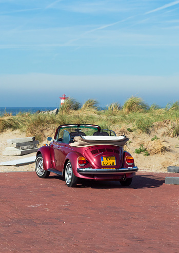 Hague, The Netherlands -October 05, 2018: Rear view of red parked volkswagen cabriolet at Shveningen beach