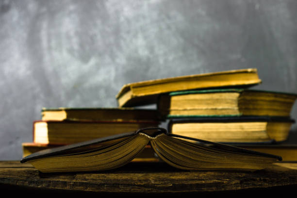 istock Old books on a oak wooden table. Beautiful dark background. 1060418430