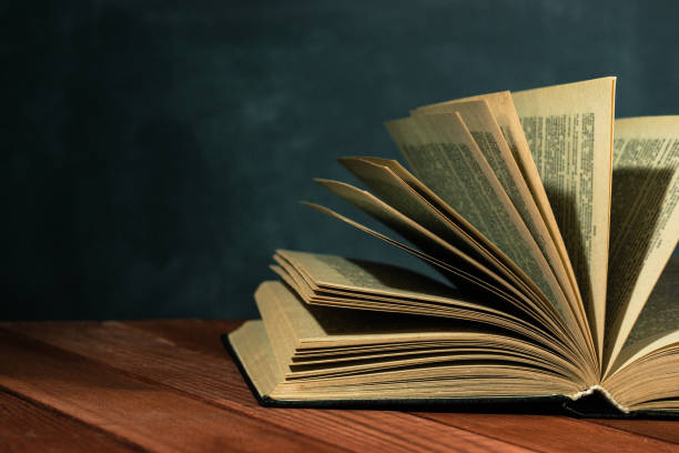 istock Old books on a wooden red table. Beautiful dark background. 1060426028
