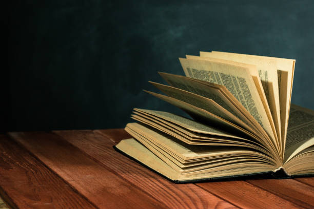 istock Old books on a wooden red table. Beautiful dark background. 1060426380