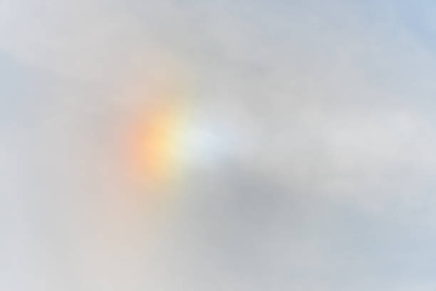 Round rainbow in the cloudy sky. View from the airplane window.
